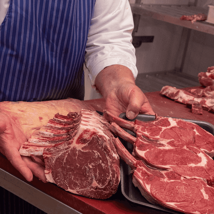 A Midland Foods butcher preparing a rib of beef