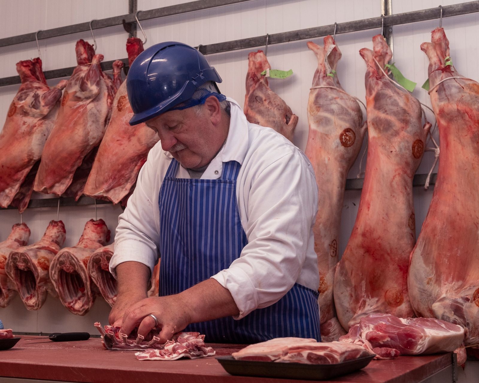 A Midland Foods butcher at work preparing cuts at the bench